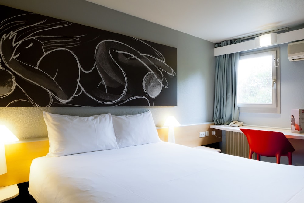 Habitación con cama doble con nueva ropa de cama del hotel Ibis Lyon Nord. Foto 1