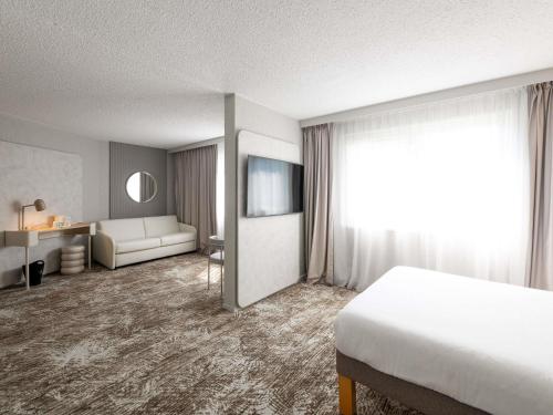 Habitación estándar con 1 cama doble y 3 camas individuales del hotel Novotel Macon Nord Autoroute du Soleil. Foto 1