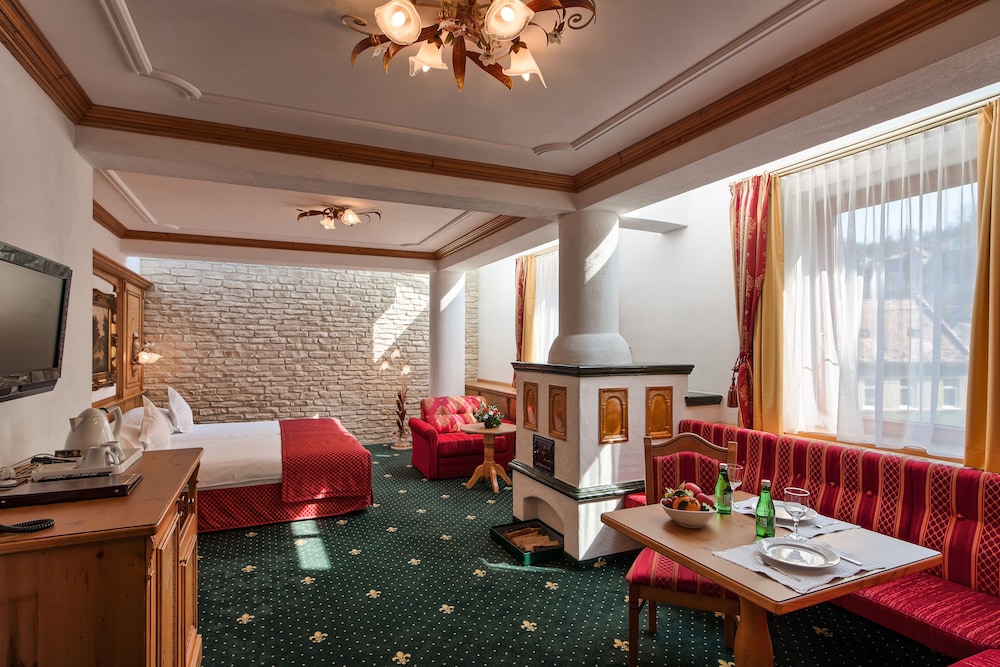 Suite de categoría superior con una cama doble y sofá del hotel Mercure Sighisoara Binderbubi - and Spa. Foto 3