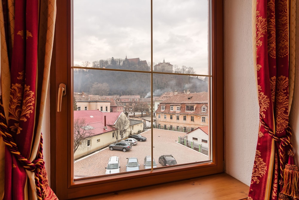 Suite de categoría superior con una cama doble y sofá del hotel Mercure Sighisoara Binderbubi - and Spa. Foto 13