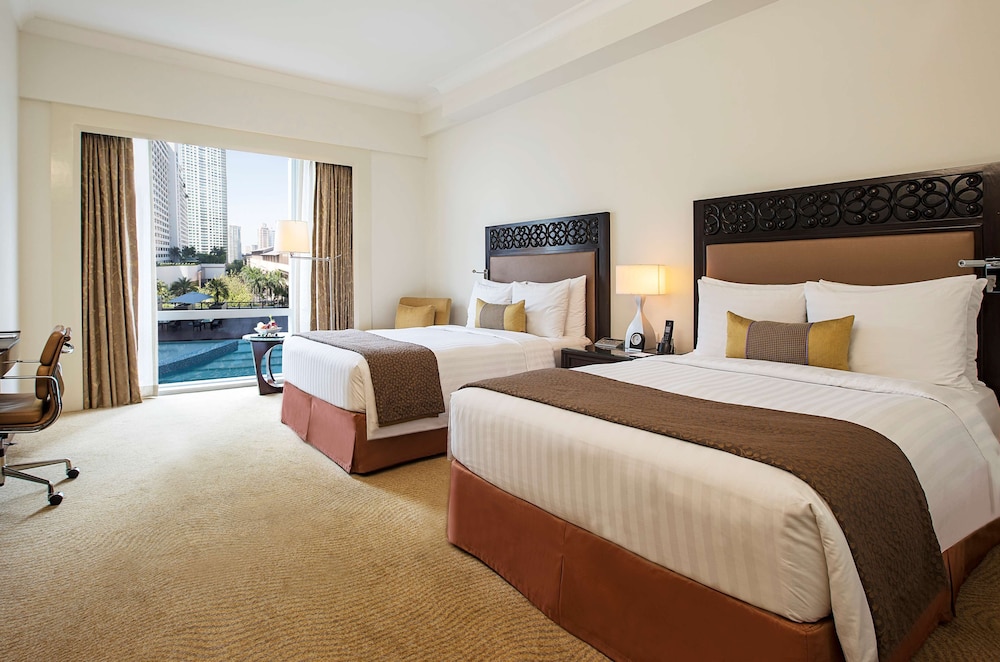Habitación Deluxe con 2 camas dobles y vistas a la piscina del hotel Fairmont Makati