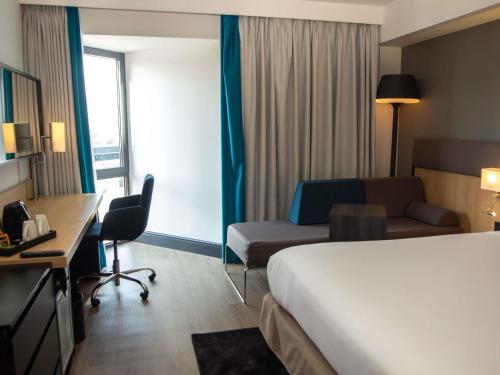 Habitación Superior con cama grande y sofá del hotel Novotel London Wembley. Foto 1