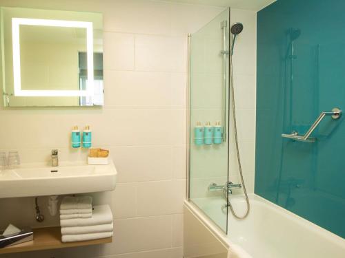Suite Superior con cama grande y sofá del hotel Novotel London Wembley. Foto 10