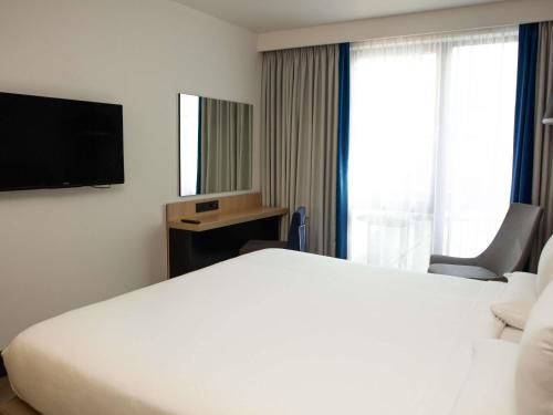 Suite Superior con cama grande y sofá del hotel Novotel London Wembley. Foto 9