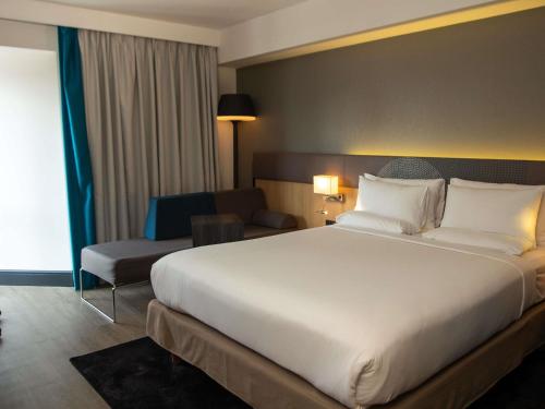 Habitación Superior con cama grande y sofá del hotel Novotel London Wembley. Foto 4