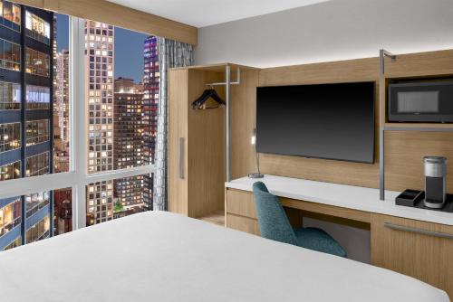 Habitación con cama extragrande y ventanal del hotel Hilton Garden Inn New York/manhattan-midtown East