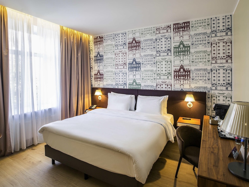 Suite Junior exclusivamente para no fumadores con cama king size y sofá del hotel Mercure Riga Centre. Foto 1