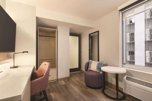 Habitación con cama extragrande y vistas parciales a lugares de interés del hotel DoubleTree by Hilton New York Midtown Fifth Ave. Foto 3