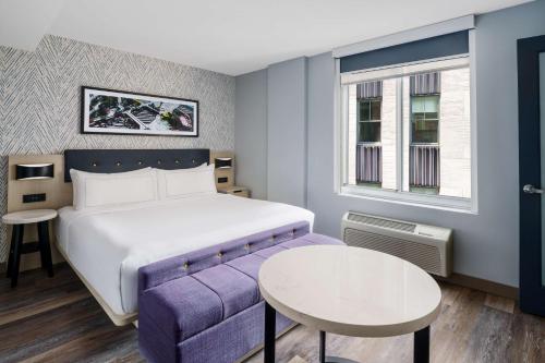 Habitación con cama extragrande y vistas parciales a lugares de interés del hotel DoubleTree by Hilton New York Midtown Fifth Ave. Foto 7