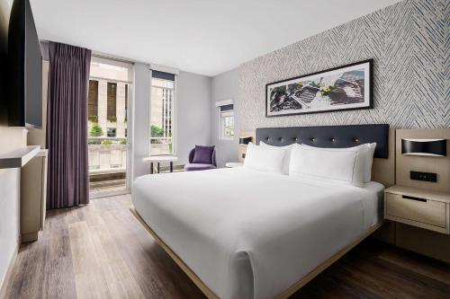 Habitación con cama extragrande y balcón del hotel DoubleTree by Hilton New York Midtown Fifth Ave. Foto 5