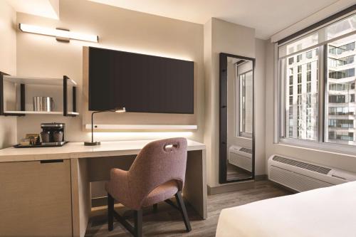 Habitación con cama grande y vistas parciales a lugares de interés del hotel DoubleTree by Hilton New York Midtown Fifth Ave