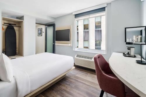 Habitación con cama grande y vistas parciales a lugares de interés del hotel DoubleTree by Hilton New York Midtown Fifth Ave. Foto 5