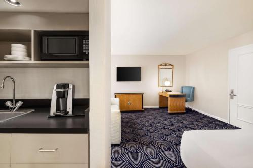 Habitación con zona de cocina y sofá cama - 1 cama extragrande del hotel Inn at Great Neck