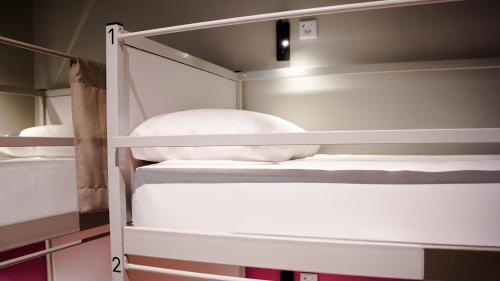 Cama en habitación compartida femenina con 4 camas y vistas a la ciudad del hotel Room Casa Gracia