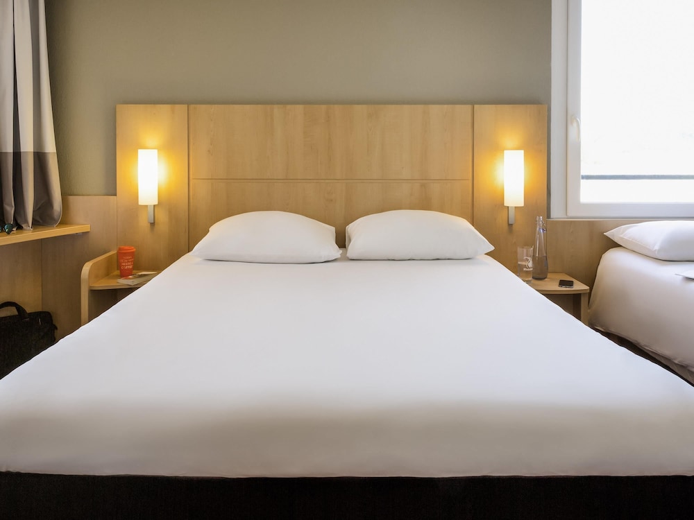 Habitación con 1 cama doble de 160 x 200 cm y 1 cama individual de 80 x 200 cm con nueva ropa de cama del hotel Ibis Lausanne Crissier. Foto 2