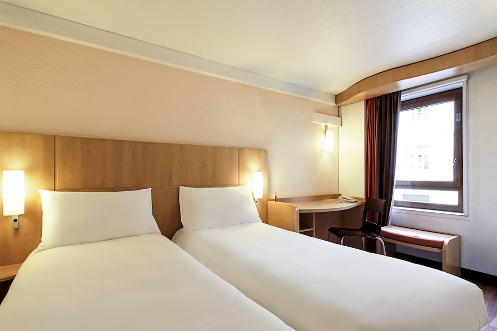 Habitación con dos camas individuales de 80x200 cm con nueva ropa de cama del hotel Ibis Lausanne Crissier. Foto 1