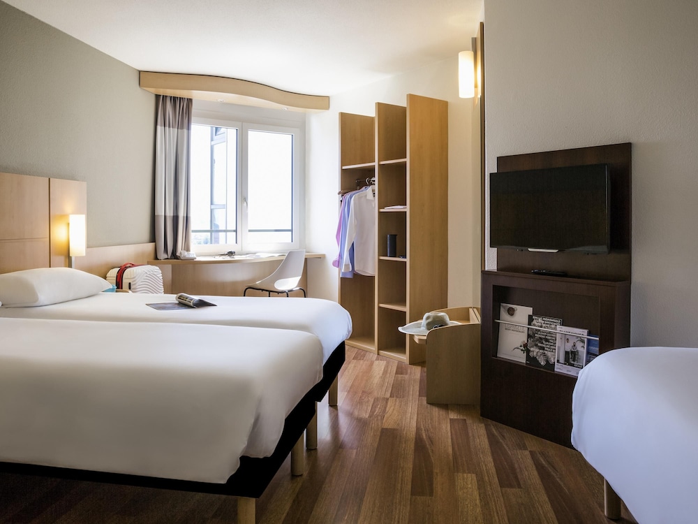 Habitación con 3 camas individuales de 80x200 cm con nueva ropa de cama del hotel Ibis Lausanne Crissier. Foto 1