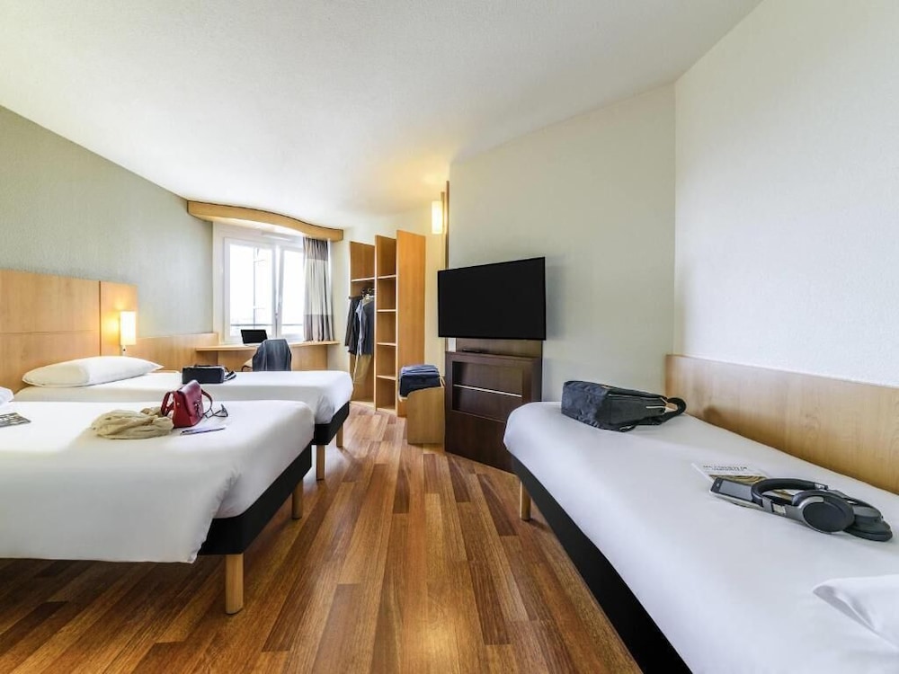 Habitación con 3 camas individuales de 80x200 cm con nueva ropa de cama del hotel Ibis Lausanne Crissier. Foto 3