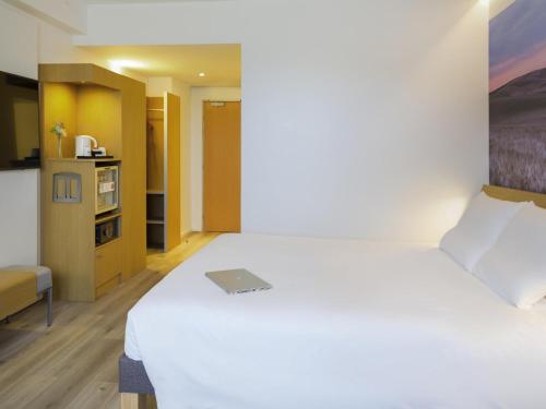 Habitación Superior con cama grande y sofá del hotel Novotel Sevilla