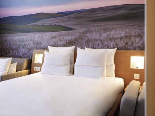 Habitación Superior con cama grande y sofá del hotel Novotel Sevilla. Foto 4