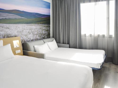 Habitación Superior con cama grande y sofá del hotel Novotel Sevilla. Foto 5