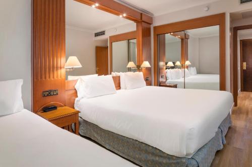 Habitación Doble con cama supletoria del hotel Exe Sevilla Macarena. Foto 1