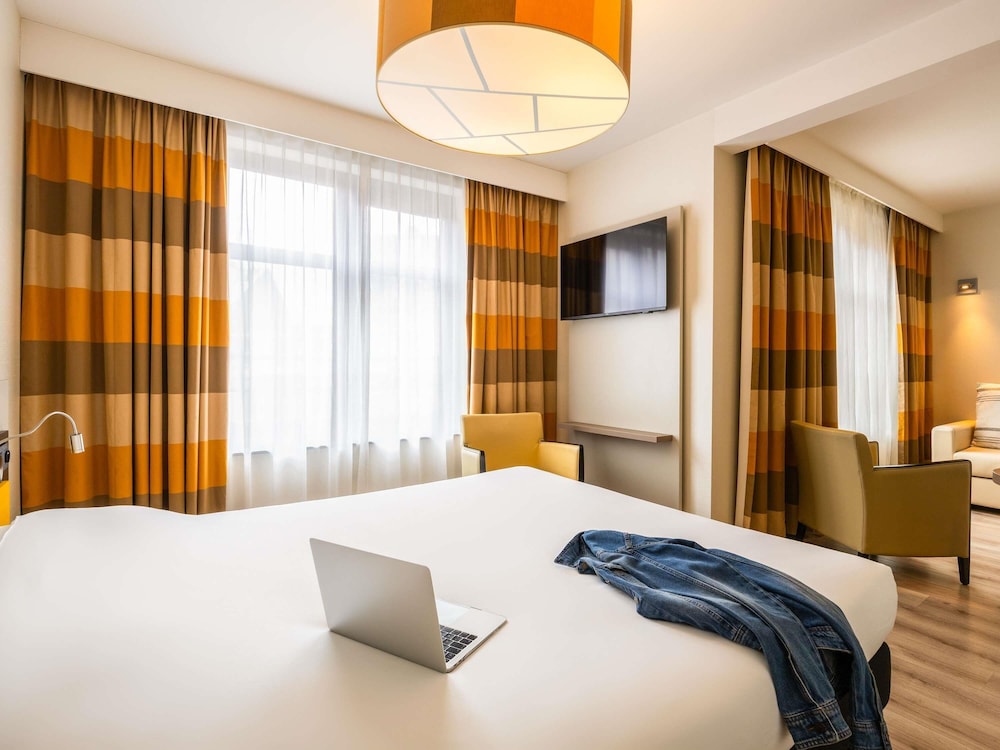 Suite con cama doble y zona de estar con sofá - cama del hotel Ibis Styles Brussels Centre Stephanie. Foto 1