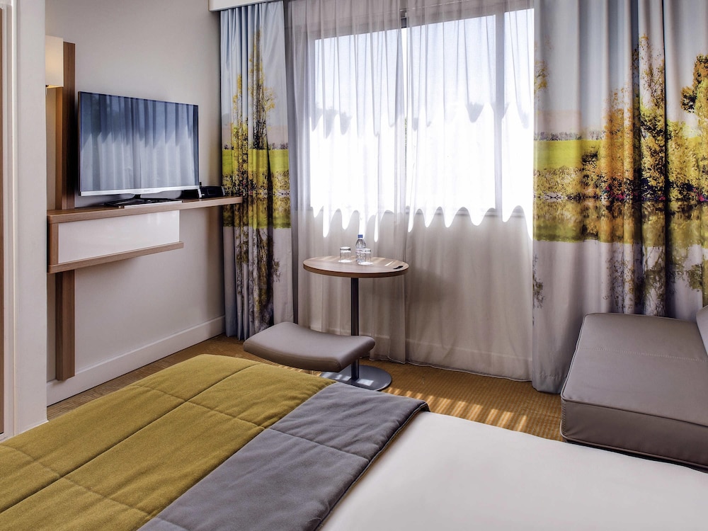Habitación familiar de categoría superior con una cama king size y un sofá cama doble del hotel Mercure Macon Bord De Saône. Foto 5