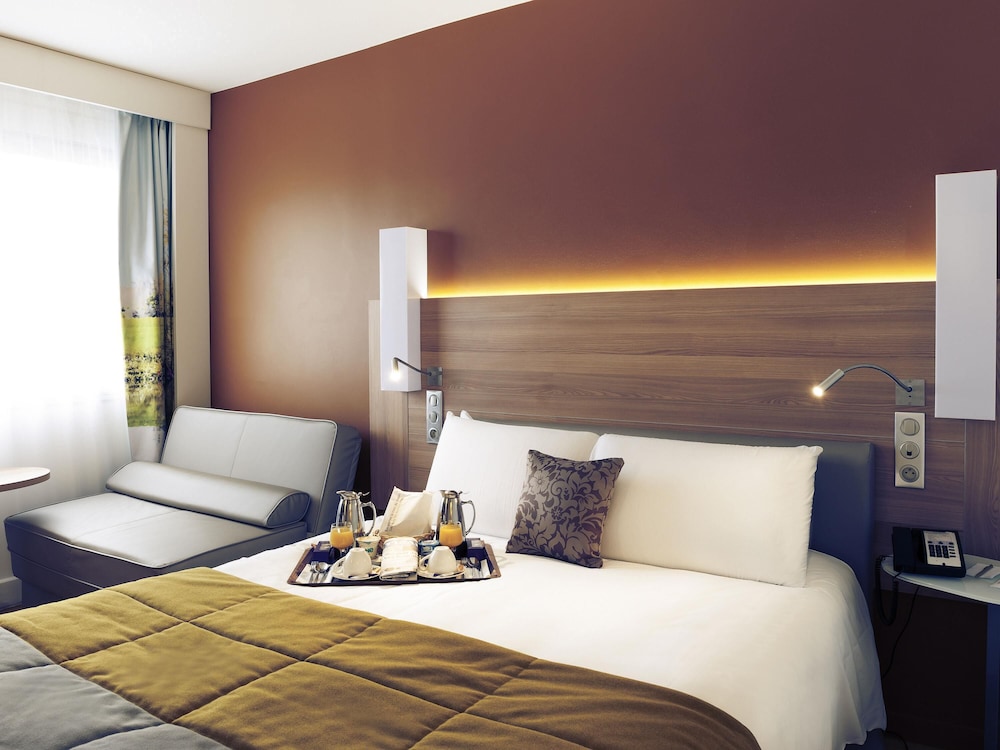HABITACIÓN PRIVILEGE con una cama king size y un sofá cama del hotel Mercure Macon Bord De Saône. Foto 7