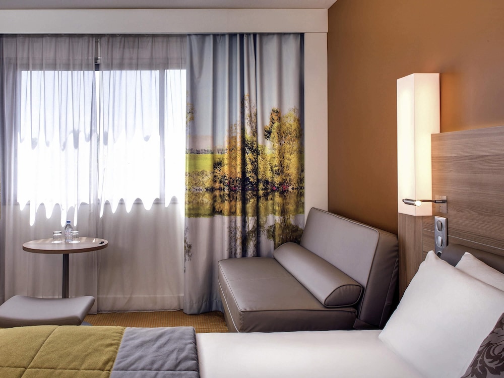 HABITACIÓN PRIVILEGE con una cama king size y un sofá cama del hotel Mercure Macon Bord De Saône. Foto 8