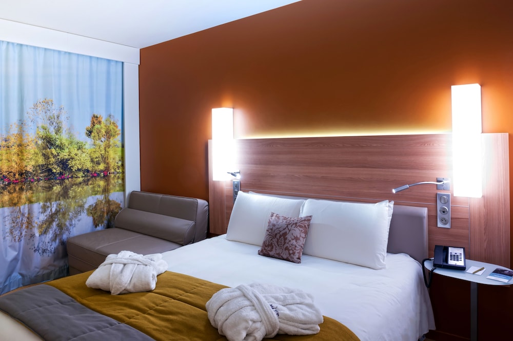 Habitación familiar de categoría superior con una cama king size y un sofá cama doble del hotel Mercure Macon Bord De Saône. Foto 11