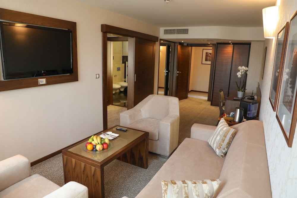 Suite Junior con cama king size y sofá; lado del río, salón independiente; Jacuzzi del hotel Movenpick Sarajevo. Foto 5
