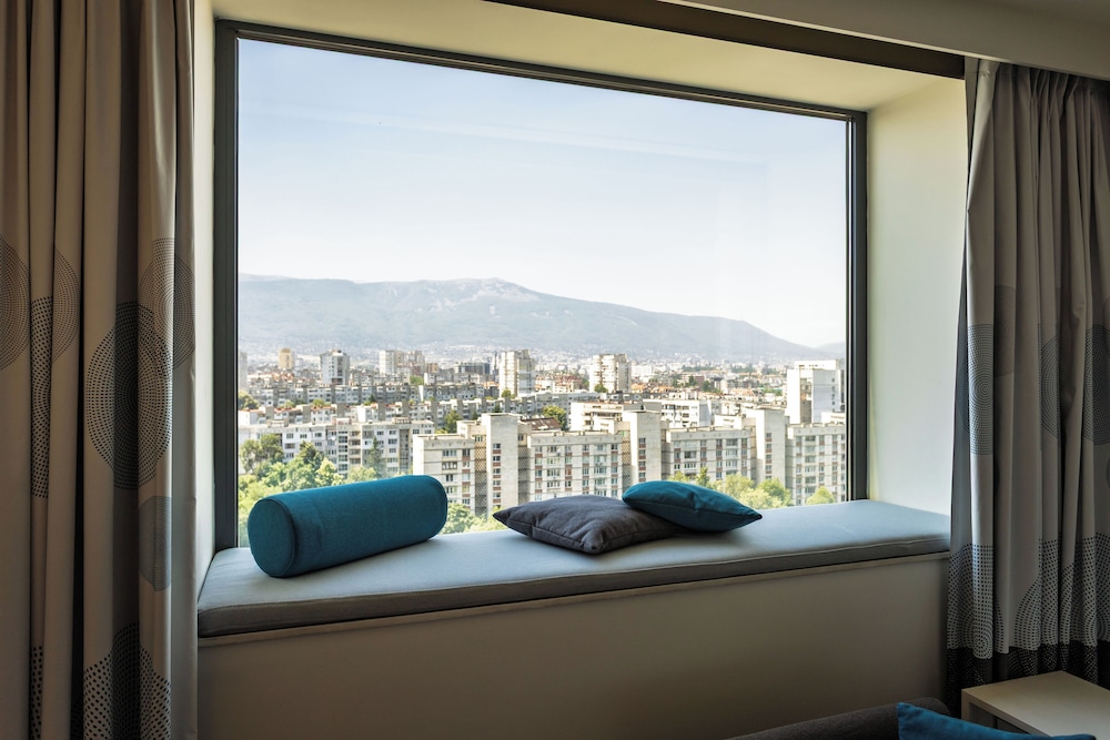 Habitación con vistas a la montaña y sofá - cama del hotel Novotel Sofia. Foto 7