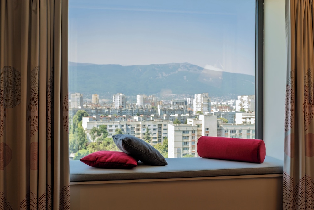 Habitación con vistas a la montaña y sofá - cama del hotel Novotel Sofia. Foto 16