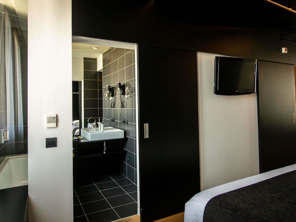 Suite Junior con 1 cama king size y sofá del hotel Mercure Villefranche En Beaujolais Ici and La. Foto 4