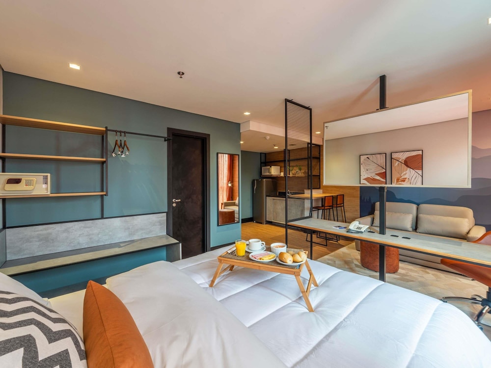 Habitación Deluxe con 1 cama queen size y sofá del hotel Manhattan Porto Alegre By Mercure. Foto 1