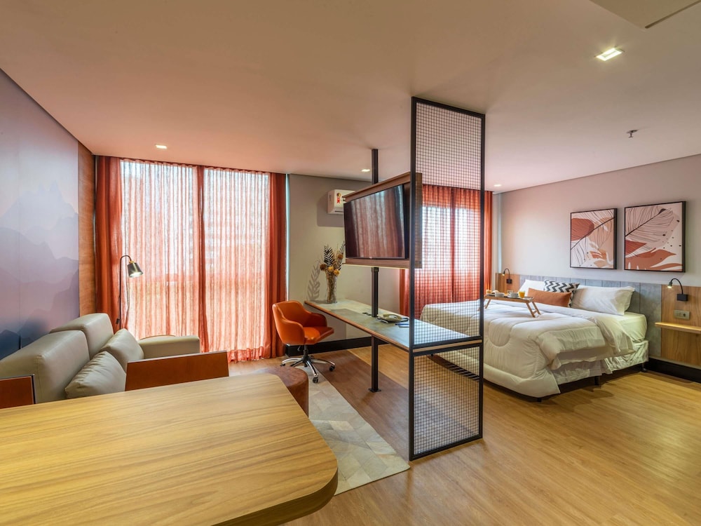 Habitación Deluxe con 1 cama queen size y sofá del hotel Manhattan Porto Alegre By Mercure. Foto 7