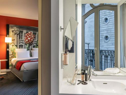 Suite con una cama doble y un sofá cama individual del hotel Mercure Lille Centre Grand Place. Foto 2