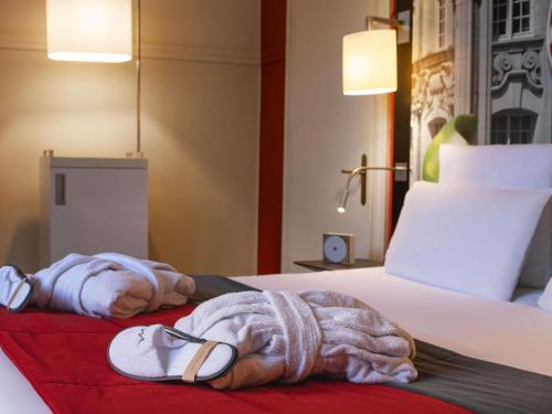 Suite con una cama doble y un sofá cama individual del hotel Mercure Lille Centre Grand Place. Foto 3