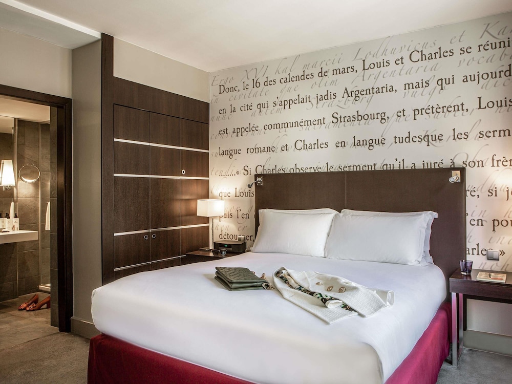 SUITE JUNIOR con una cama king size y zona de salón del hotel Sofitel Strasbourg Grande Ile