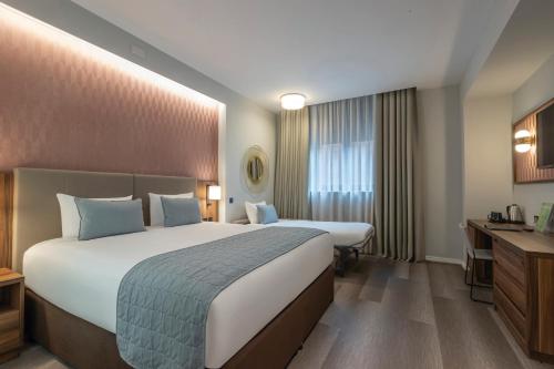 Habitación Deluxe Familiar - cama extragrande del hotel Riu Plaza The Gresham Dublin. Foto 3