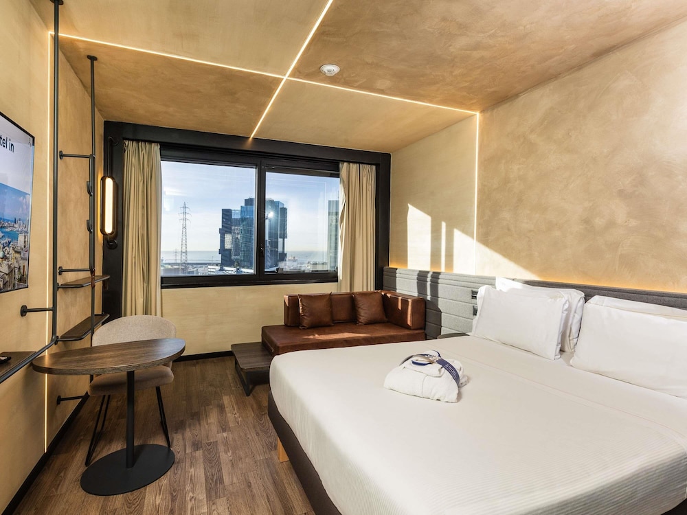 Habitación Ejecutiva con cama doble y sofá del hotel Novotel Genova City. Foto 3