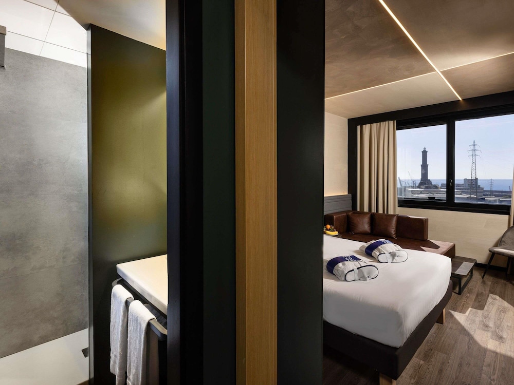 Habitación Ejecutiva con cama doble y sofá del hotel Novotel Genova City. Foto 4