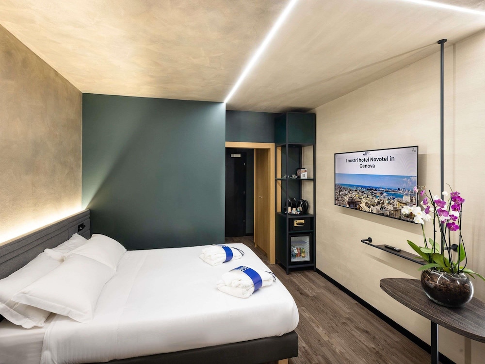 Habitación Ejecutiva con cama doble y sofá del hotel Novotel Genova City. Foto 6