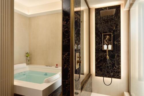 Suite con bañera de hidromasaje, balcón, terraza y vistas a la ciudad del hotel FH55 Grand Hotel Palatino