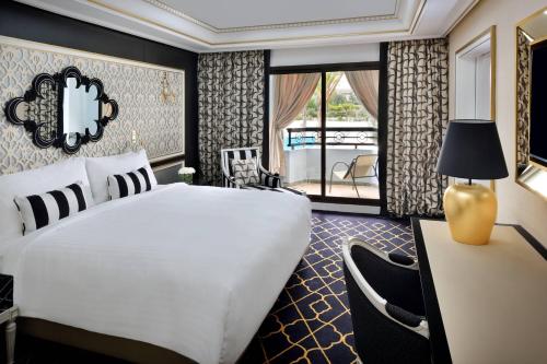 Suite Junior con sofá cama, balcón y vistas al jardín y a la piscina - Cama extragrande del hotel Fes Marriott Jnan Palace