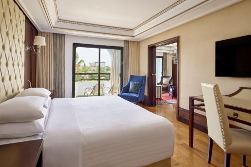 Suite Executive con sofá cama y vistas al jardín y a la piscina - Cama extragrande del hotel Fes Marriott Jnan Palace. Foto 2