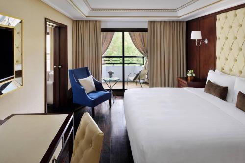 Suite Executive con sofá cama y vistas al jardín y a la piscina - Cama extragrande del hotel Fes Marriott Jnan Palace