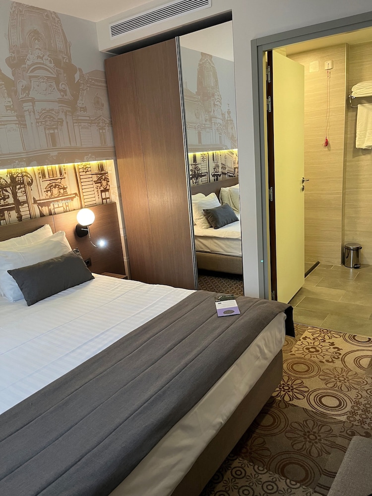 Suite Privilege con 1 cama doble y sofá del hotel Mercure Bucharest City Center. Foto 1