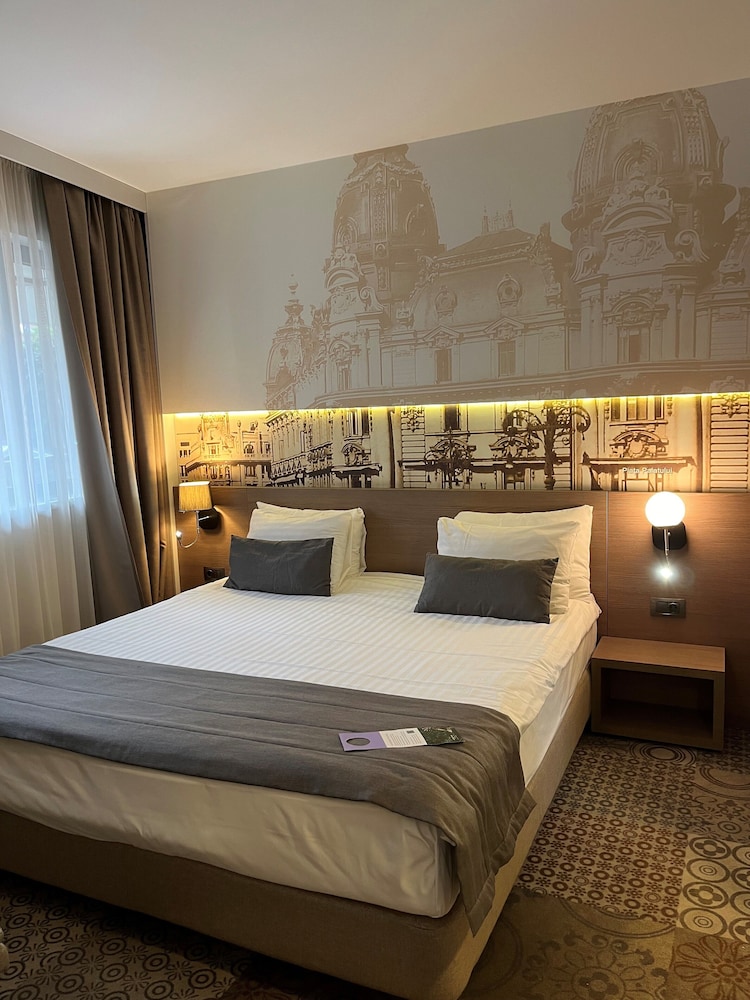 Suite Privilege con 1 cama doble y sofá del hotel Mercure Bucharest City Center. Foto 2